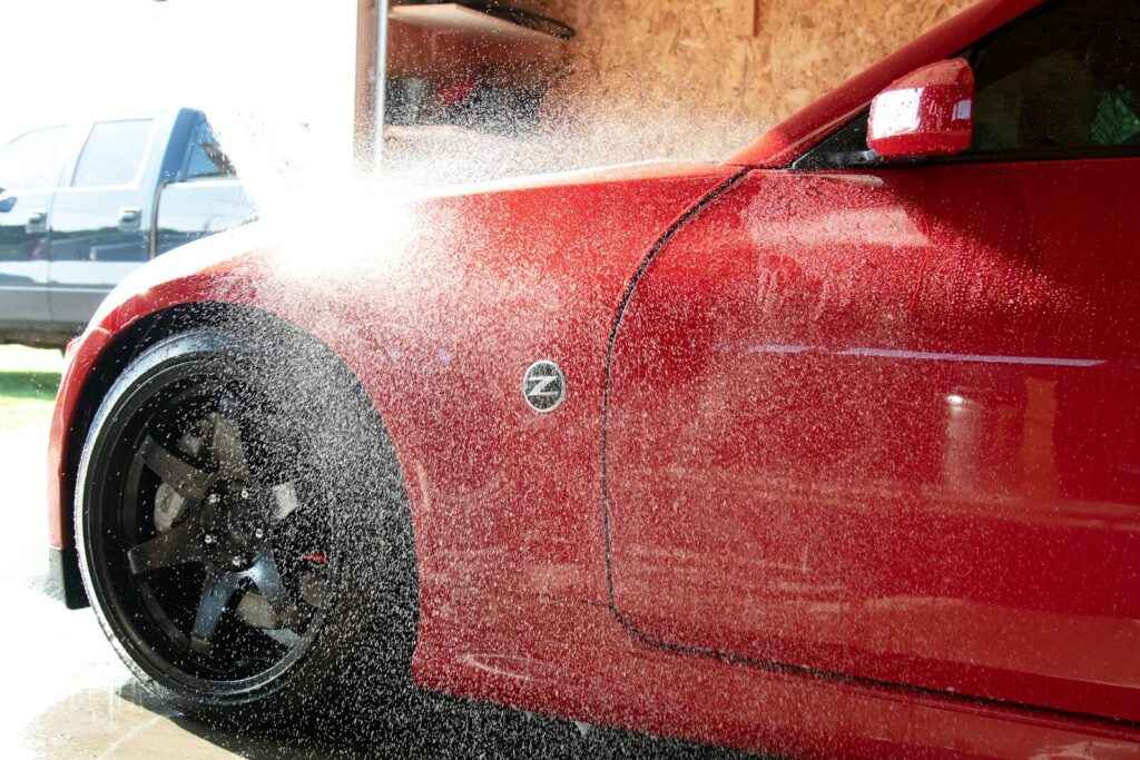 a red car is being sprayed with water