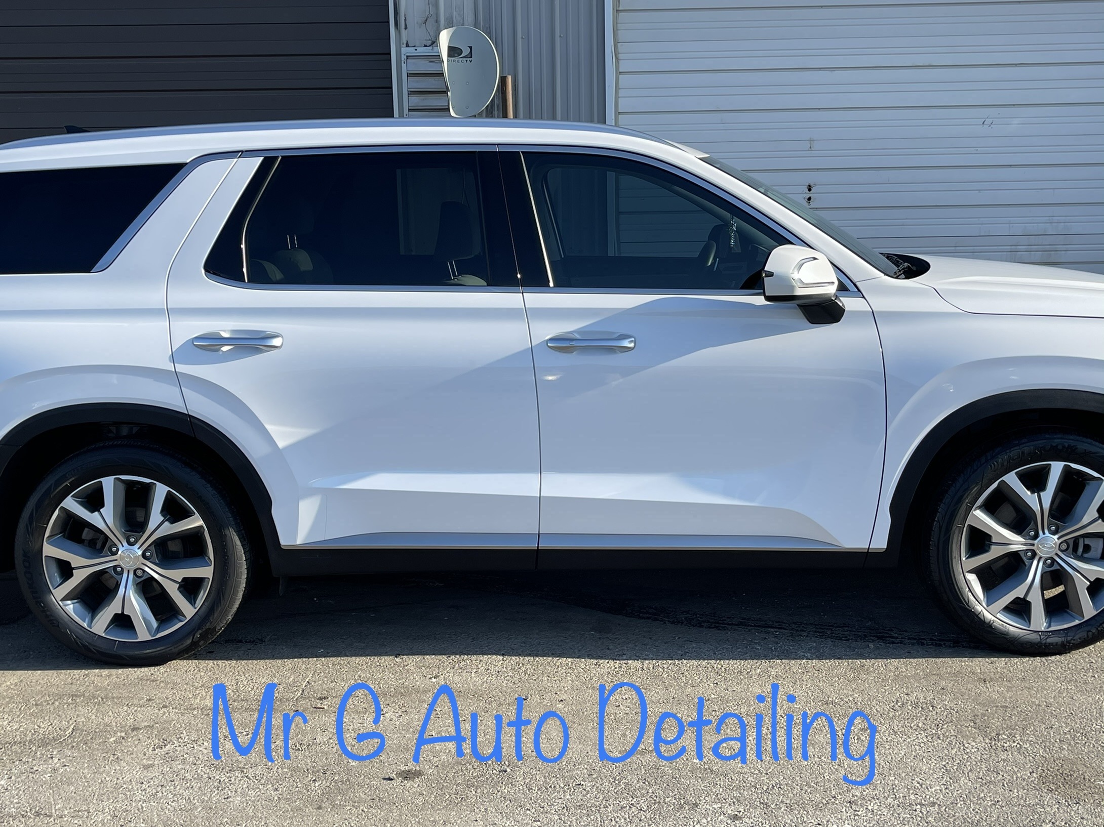 A close up of a white SUV parked on the side of a road